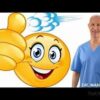 A man in blue scrubs is smiling and giving the thumbs up.