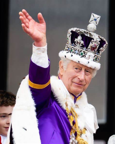 A man in a crown waving to the crowd.