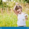 A little girl holding up her hand in the air.