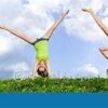 A woman doing a handstand in the grass.