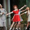 Three girls enthusiastically performing a dance on stage.
