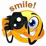 A smiley face holding a camera with the word smile written underneath it.