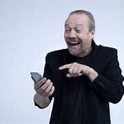 A man in black jacket holding a cell phone.